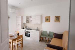 a kitchen with white cabinets and a table and chairs at CasaRiso in Grammichele