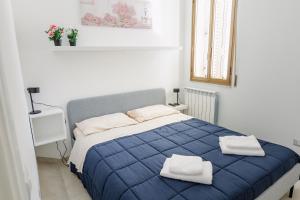 um quarto com uma cama azul com duas toalhas em CasaRiso em Grammichele
