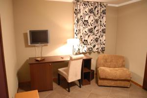 Zimmer mit einem Schreibtisch, einem Stuhl und einem TV in der Unterkunft Suite&B in Scicli