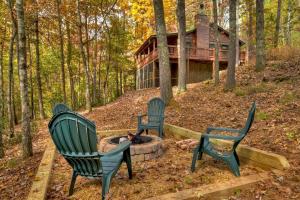 three chairs around a fire pit in front of a log cabin at Papa Bear's Den in Cherry Log