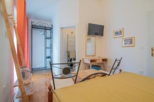 a room with a bed and a desk and a television at Hotel Villa Vera 2 in Fažana
