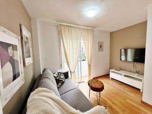 een woonkamer met een bank en een tv bij Precioso y céntrico apartamento de playa in Fuengirola
