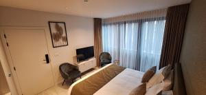une chambre d'hôtel avec un lit et une télévision dans l'établissement Den Ommegang, à Halle