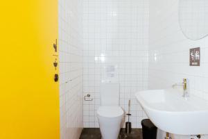 a bathroom with a white toilet and a sink at Surf & Sea Suites in Parede