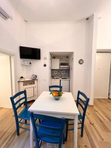 a kitchen and dining room with a white table and blue chairs at ERIC'S HOUSE in Salerno