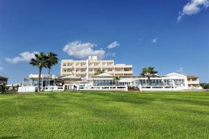 a large building with a grass field in front of it at Piere - Anne Beach Hotel in Ayia Napa