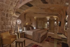 a bedroom with a bed and a desk and a chair at Acropolis Cave Suite in Urgup
