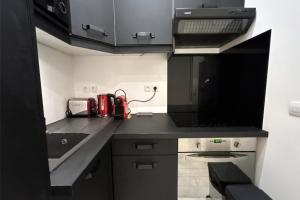 a small kitchen with a black counter top at Bright apartment in the heart of Paris in Paris