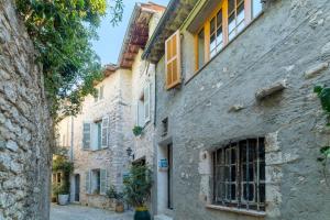 an alley in an italian town with stone buildings at Soleil & Convivialité à Saint-Paul 8P in Saint Paul de Vence