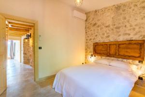 ein Schlafzimmer mit einem weißen Bett und einer Wand in der Unterkunft Soleil & Convivialité à Saint-Paul 8P in Saint-Paul-de-Vence