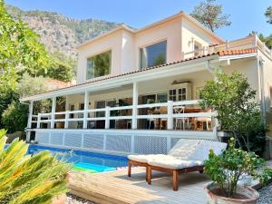 a large house with a swimming pool in front of it at Villa Storm - Very Stylish Villa w/Pool & Garden in Gocek Hills in Fethiye