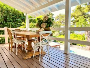 a porch with a wooden table and chairs at Villa Storm - Very Stylish Villa w/Pool & Garden in Gocek Hills in Fethiye