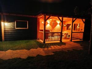 a screened in porch at night with lights at "Huisje op de Veluwe" met privé Jacuzzi en Bar! in Ermelo