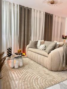 sala de estar con sofá frente a las cortinas en Luxueux Appartement Jacuzzi proche de Paris, en La Celle-Saint-Cloud