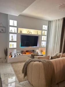sala de estar con TV y sofá en Luxueux Appartement Jacuzzi proche de Paris, en La Celle-Saint-Cloud