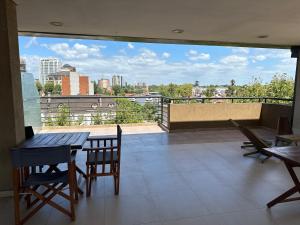 a balcony with a table and chairs and a view of a city at Departamento en Tigre con Pileta y cochera in Tigre