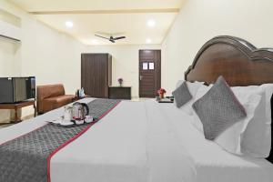 a bedroom with a large white bed and a television at OYO Townhouse 998 Hotel Monark in Jaipur