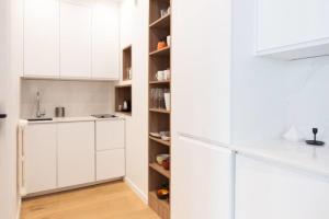 a kitchen with white cabinets and a refrigerator at Beautiful Apartment Near The Eiffel Tower in Paris