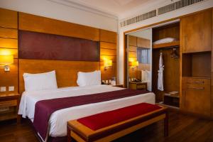 a hotel room with a large bed and a mirror at Eko Hotel Suites in Lagos