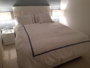 een groot wit bed in een kamer met 2 lampen bij Penthouse op Las Colinas golf & country club Hinojo 1 in Orihuela
