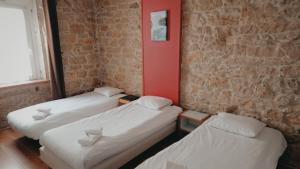 three beds in a room with a brick wall at Hôtel Hermance in Bellegarde-sur-Valserine