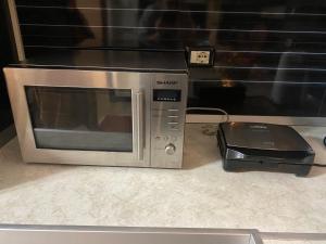 a microwave sitting on a counter next to a printer at Elbasan center family apartment n.42 in Elbasan