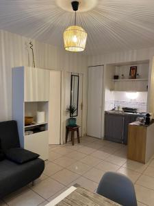 a living room with a couch and a kitchen at Appartement T2 avec Terrasse centre ville d’Aix en Provence in Aix-en-Provence