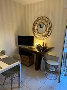 een woonkamer met een tv en een tafel met een vaas bij Appartement T2 avec Terrasse centre ville d’Aix en Provence in Aix-en-Provence