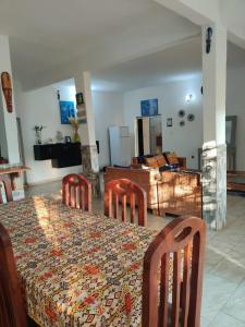 a dining room with a table with chairs and a tableablish at LES VAGUES BLEUES in Ilendé