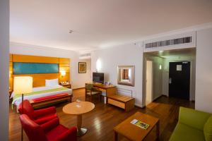une chambre d'hôtel avec un lit et un salon dans l'établissement Eko Hotel Suites, à Lagos