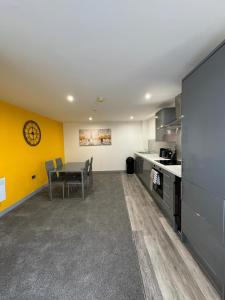 a kitchen with a table and a dining room at Flat 401 Spacious Two Bedroom in Yeadon