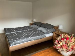 a bed in a bedroom with a vase of flowers at Vidiecky domček in Pohronská Polhora