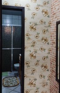 a bathroom with a wall with flowers on it at uma casa na viagem in Três Cachoeiras +9 photos