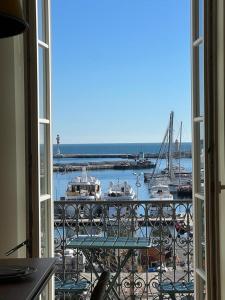 a view of a marina from an open window at IMMOGROOM - Apparements luxueux - 2min du Palais - Vue mer - Clim in Cannes