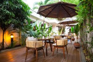 un patio extérieur avec des tables, des chaises et des parasols dans l'établissement Eko Hotel Suites, à Lagos