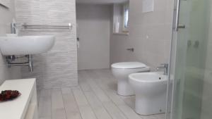 a bathroom with a toilet and a sink and a shower at Le Pigne casa vacanze. in Pollica