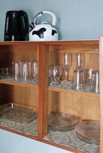 a wooden shelf with glasses and a tea pot at uma casa na viagem in Três Cachoeiras