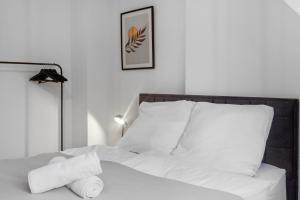a bed with white sheets and a pile of pillows at Skyview Retreat Maisonette in Essen