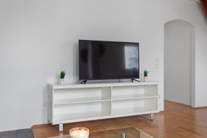 a white entertainment center with a flat screen tv on it at Skyview Retreat Maisonette in Essen