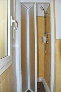 a shower with a glass door in a bathroom at Kyaala Djadsal Moradias pool&sea in Santa Maria