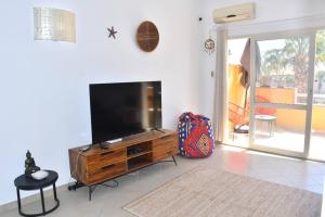 a living room with a large flat screen tv at Kyaala Djadsal Moradias pool&sea in Santa Maria
