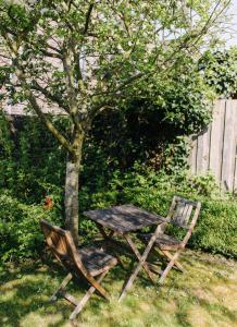 a table and two chairs sitting next to a tree at Charmantes Stadthaus in Husum