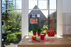 a kitchen counter with a window and a table with food at Charmantes Stadthaus in Husum