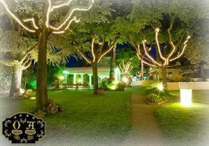 een tuin met bomen en een huis met verlichting bij Oscar e Amorina in Montegiorgio