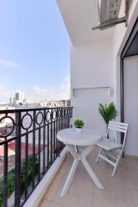 un tavolo bianco e una sedia sul balcone di Appartement Charmant & Cozy - Centre ville de Rabat a Rabat