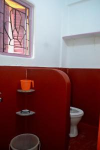 een badkamer met een toilet en een glas-in-loodraam bij Gayitri in Calcutta