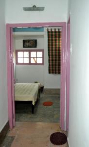 een kamer met een slaapkamer met een bed en een raam bij Gayitri in Calcutta