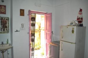 een keuken met een witte koelkast en een wastafel bij Gayitri in Calcutta