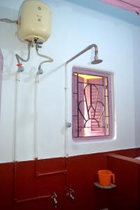 een badkamer met een glas-in-loodraam en een wastafel bij Gayitri in Calcutta