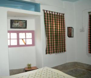 een slaapkamer met een bed en een raam bij Gayitri in Calcutta